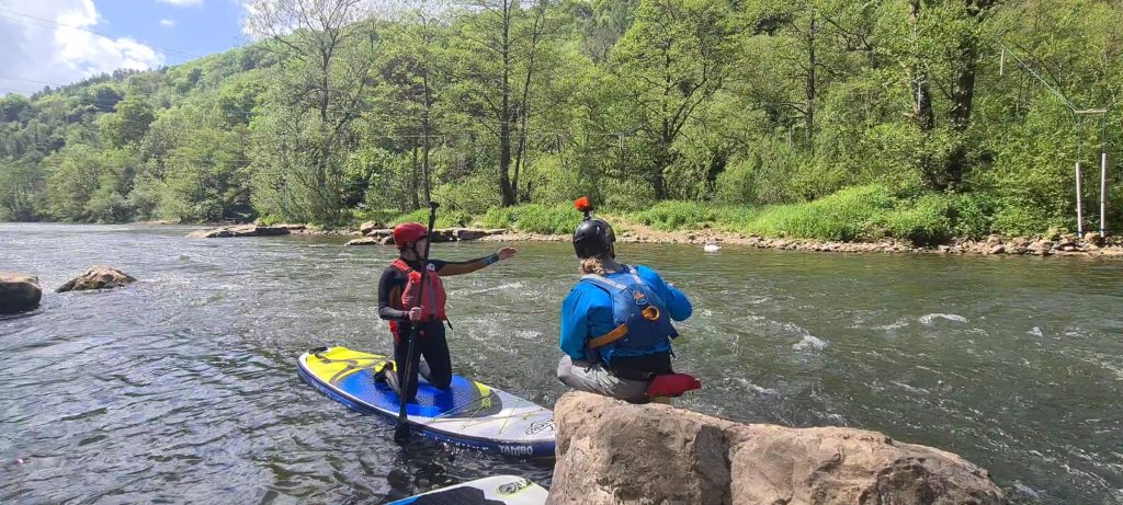 Whitewater SUP coach teaching student