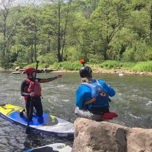 Whitewater SUP coach teaching student